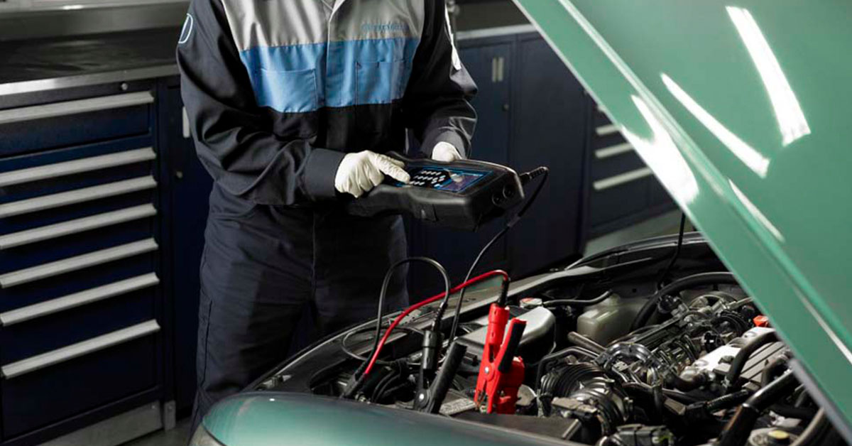 Honda service technician inspecting a battery