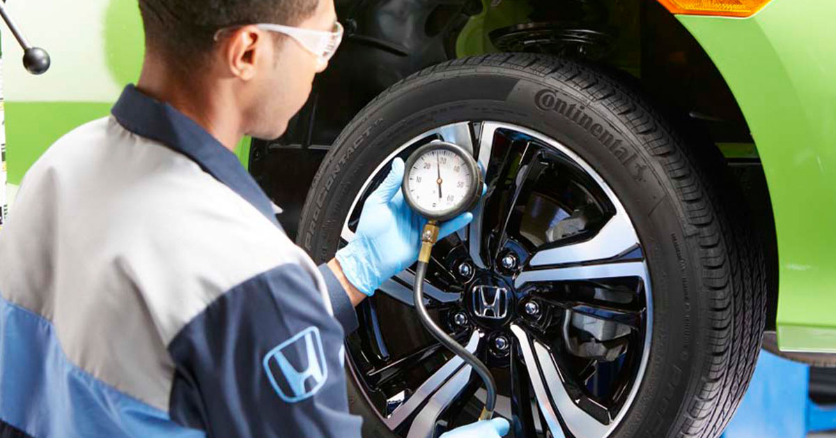 Technician inspecting Honda tires
