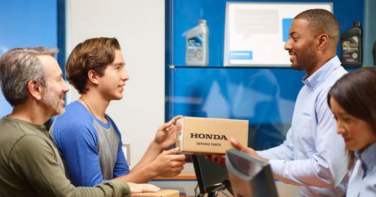Dealer handing Honda parts to a customer
