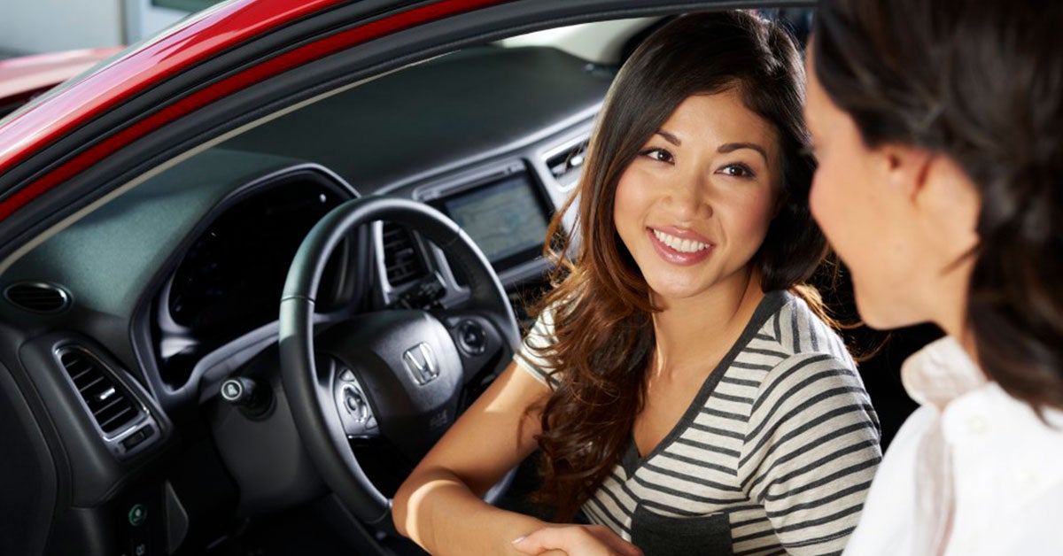 Woman sitting in a Honda, shaking hands